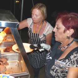 Sue & Stella Serving the Spit Roast