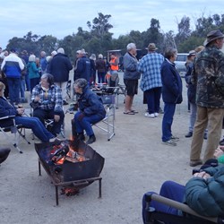 Happy hour keeping warm around the fire drums.