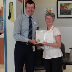 Peta accepting a certificate of appreciation from the manager.