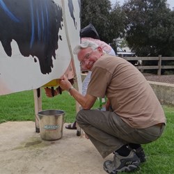 Alex having a go at "milking" the cow.