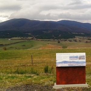 The plaque tells the story with the crash site in the background.