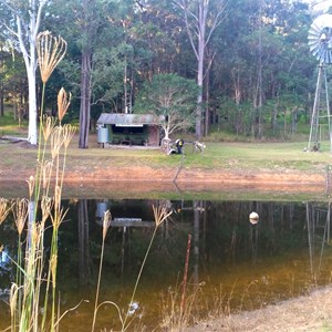 Rustic bush hut and 1954 windmill on Forgedale Farm Dam