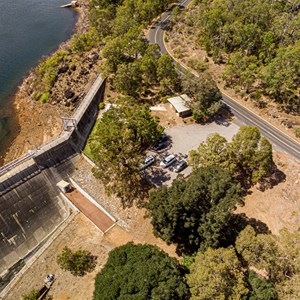 Toilet block and carpark alongside weir wall